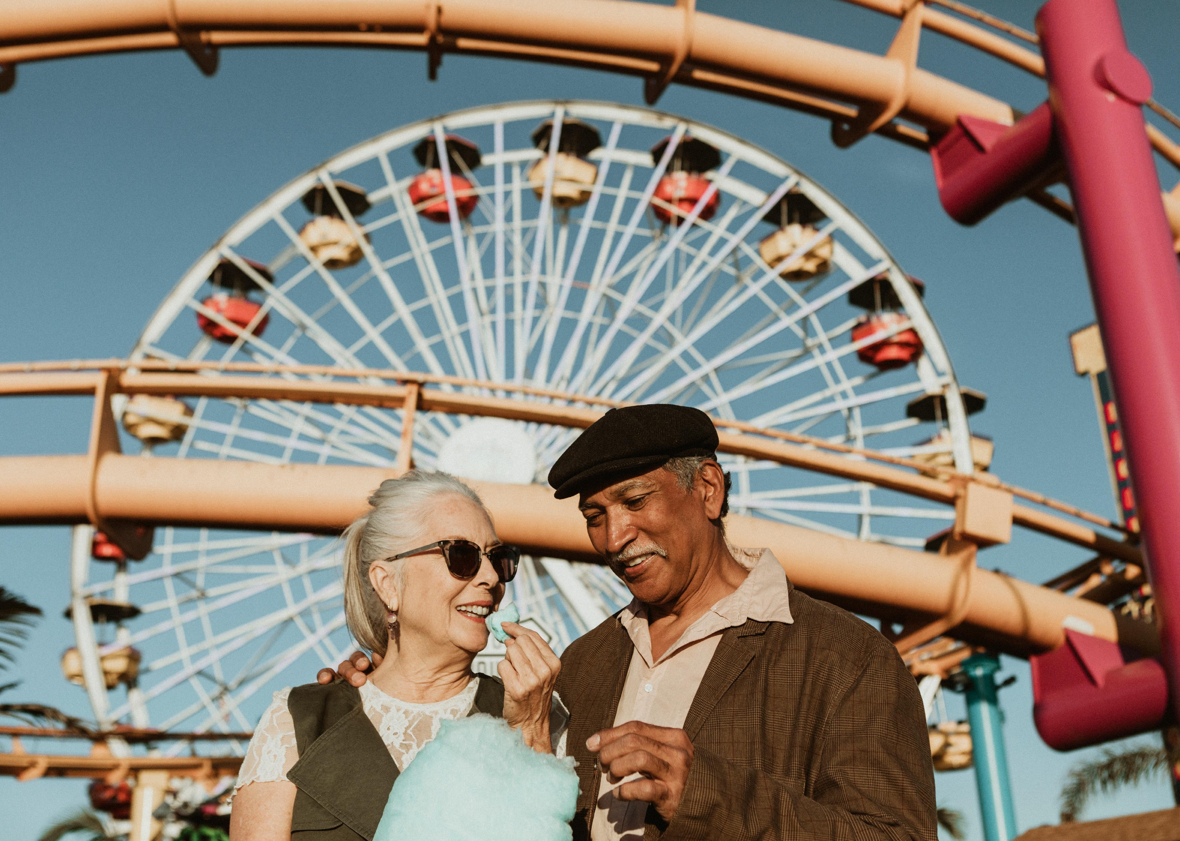 Elderly couple enjoying cotton candy at Pacific Park in Santa Monica.