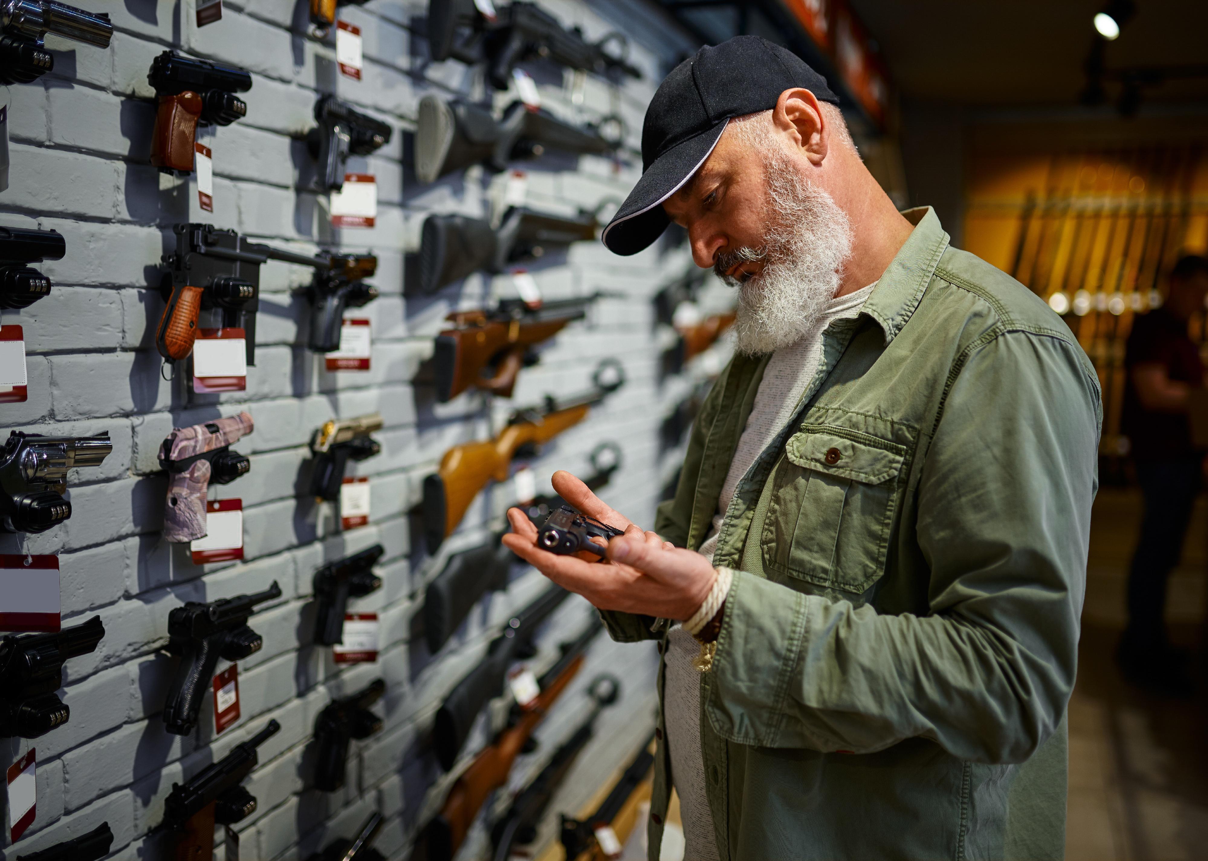 Person holds pistol in a gun store.