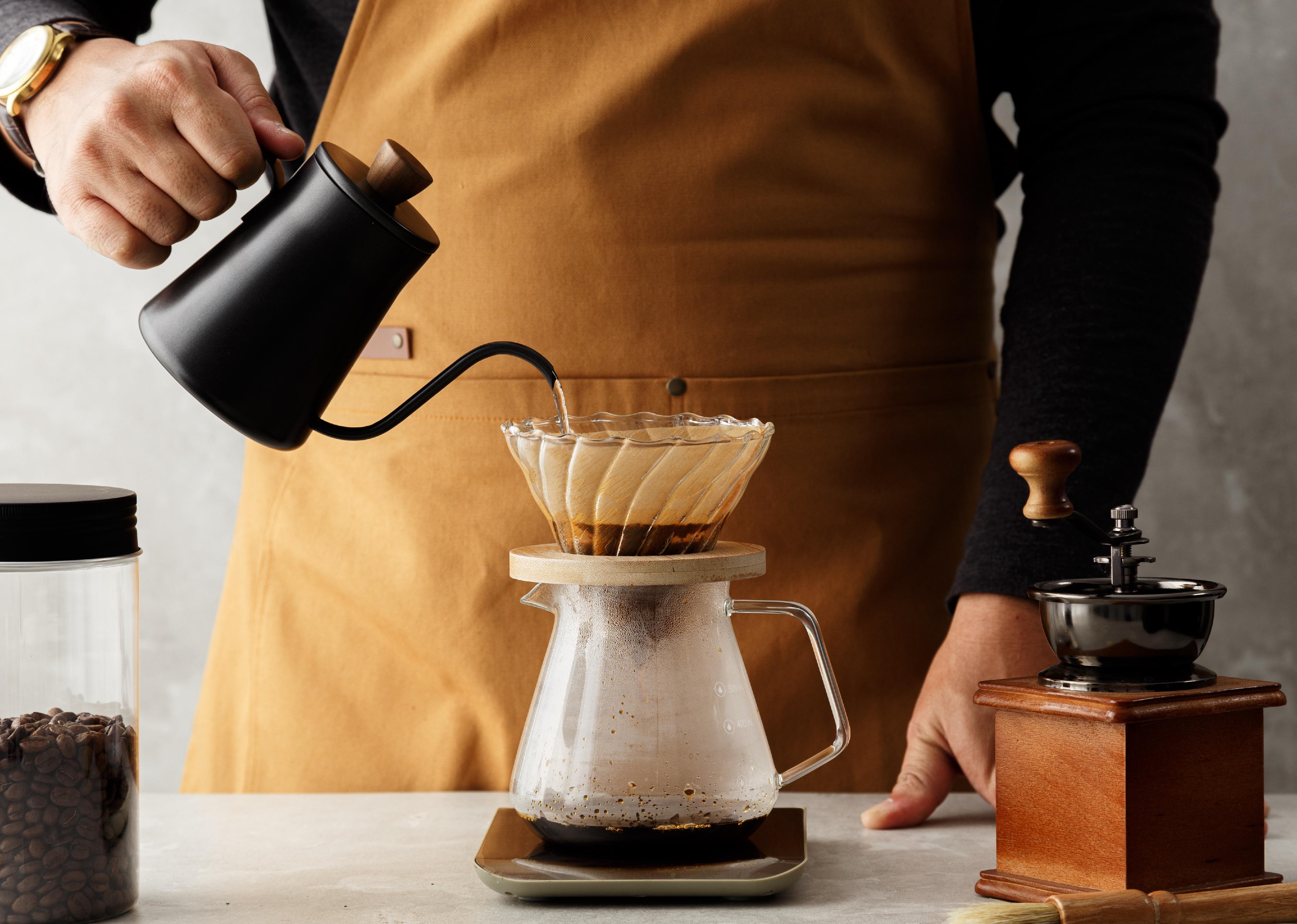 Male barista making a drip coffee.