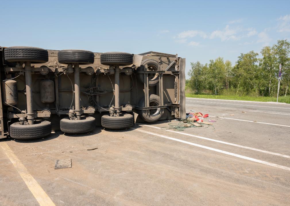 A truck is lying on its side after a car accident on the highway