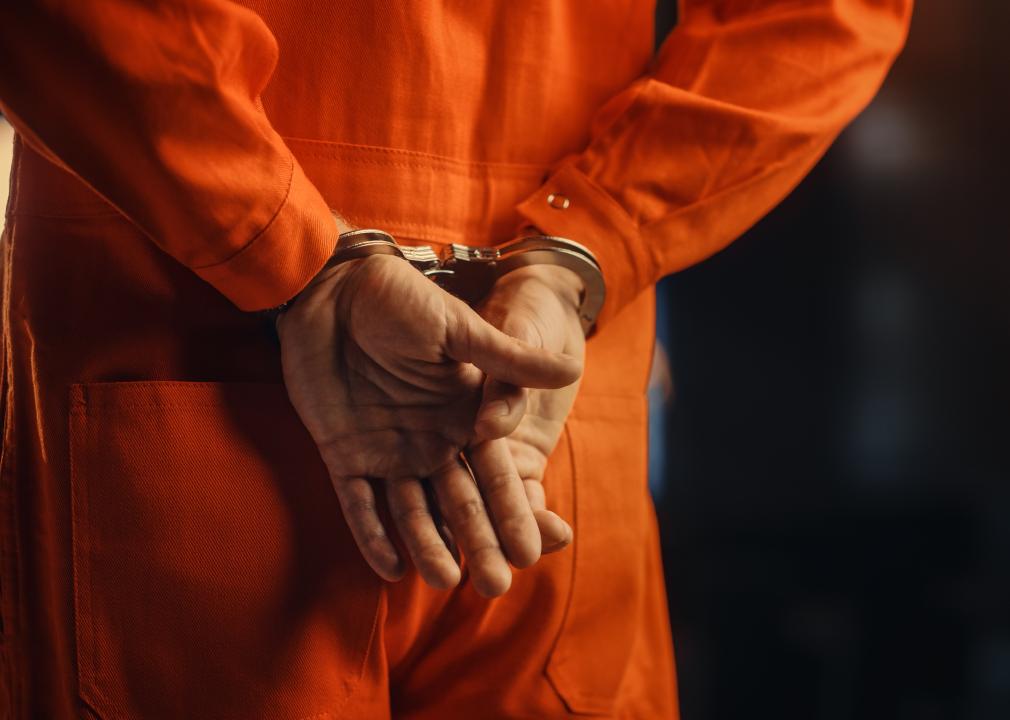 Handcuffs on an inmate in an orange jumpsuit.