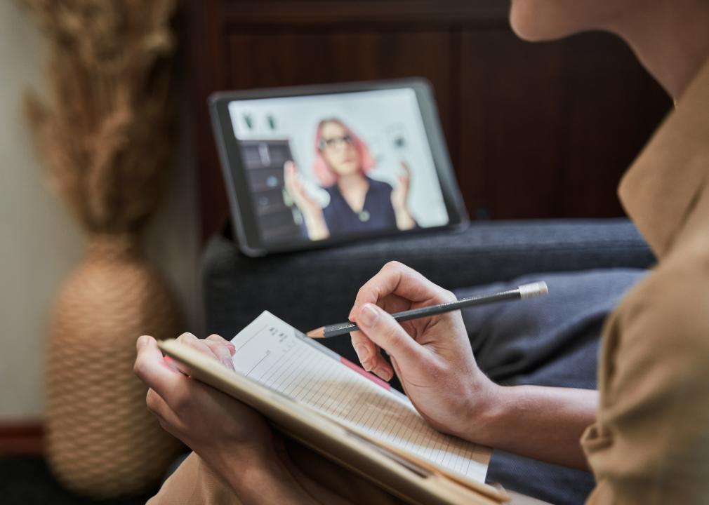 Female psychotherapist taking notes during an online session
