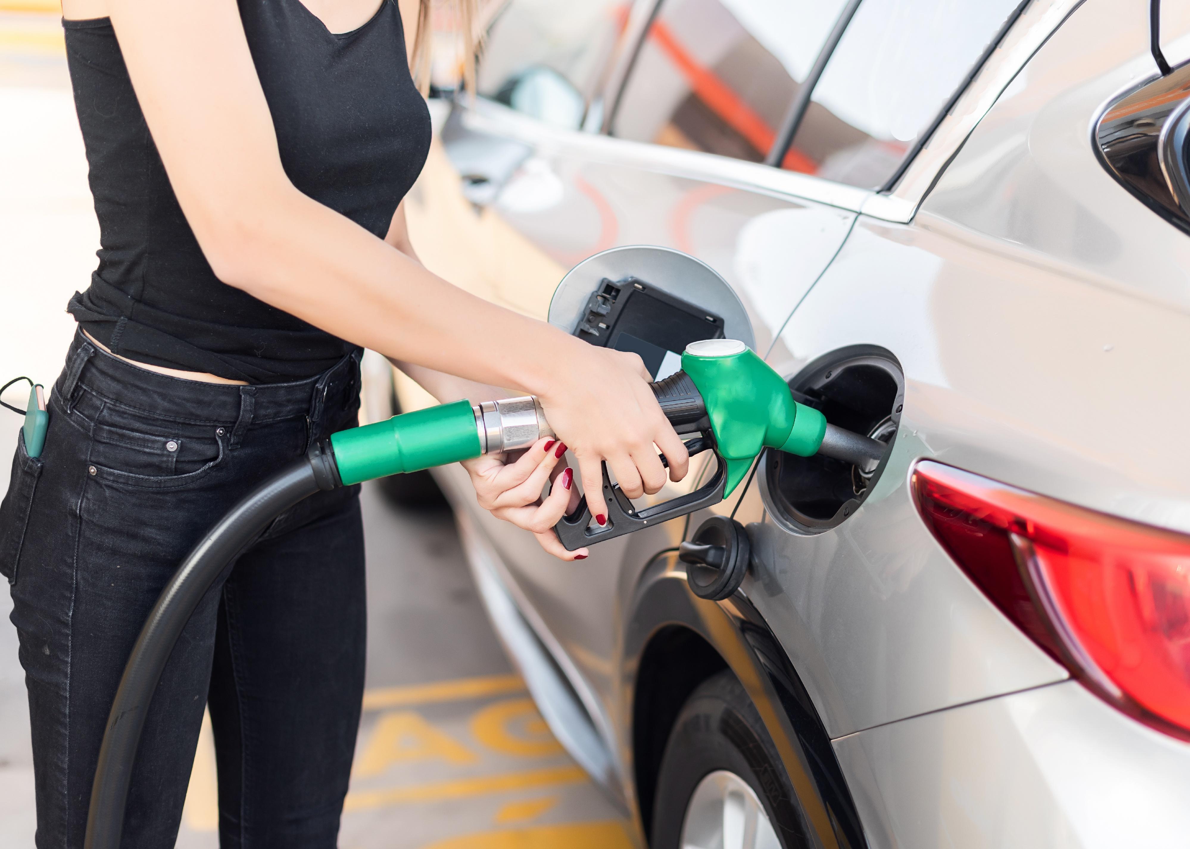 Close up of a young woman getting gas