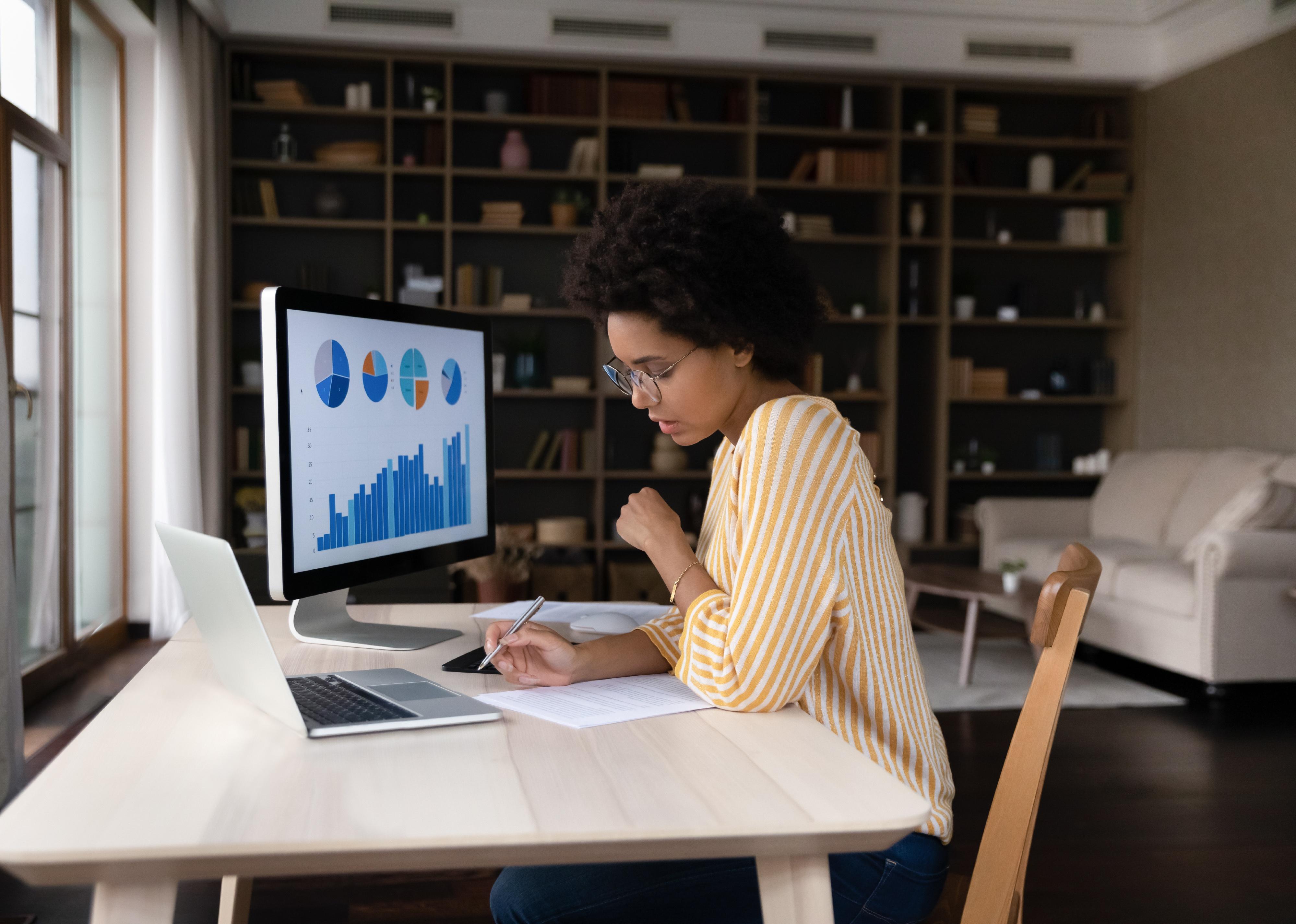 Concentrated businessperson analyzing online sales statistics data on computer.