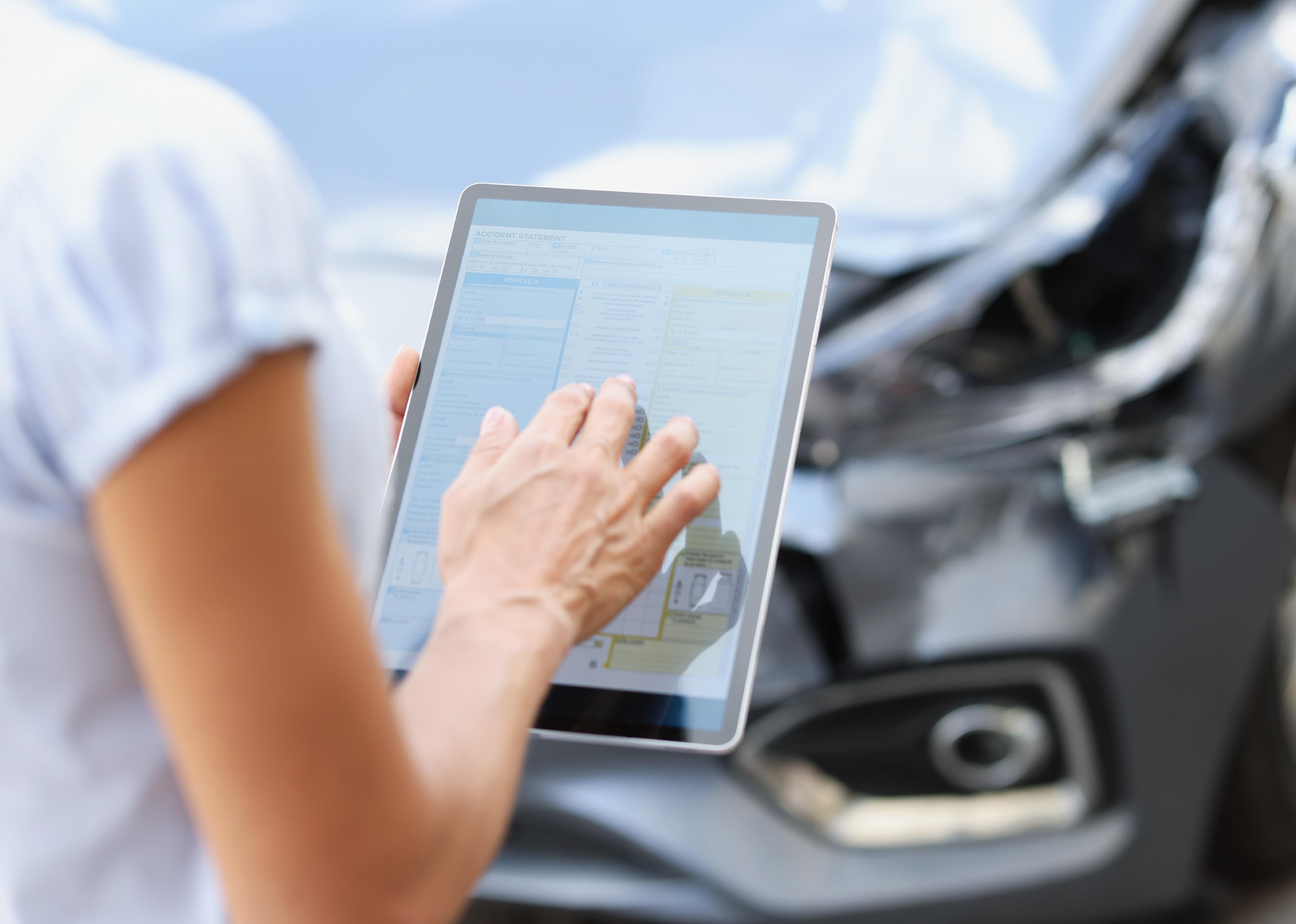 Female agent filling in insurance application on digital tablet 