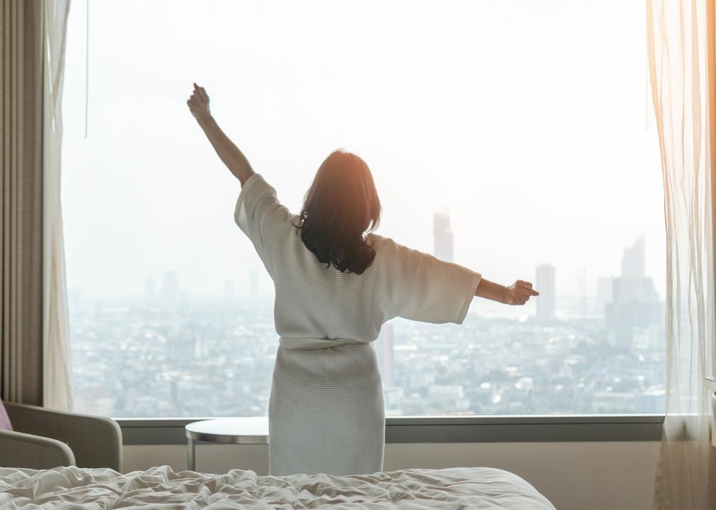 A woman wakes up in a hotel room wearing a robe