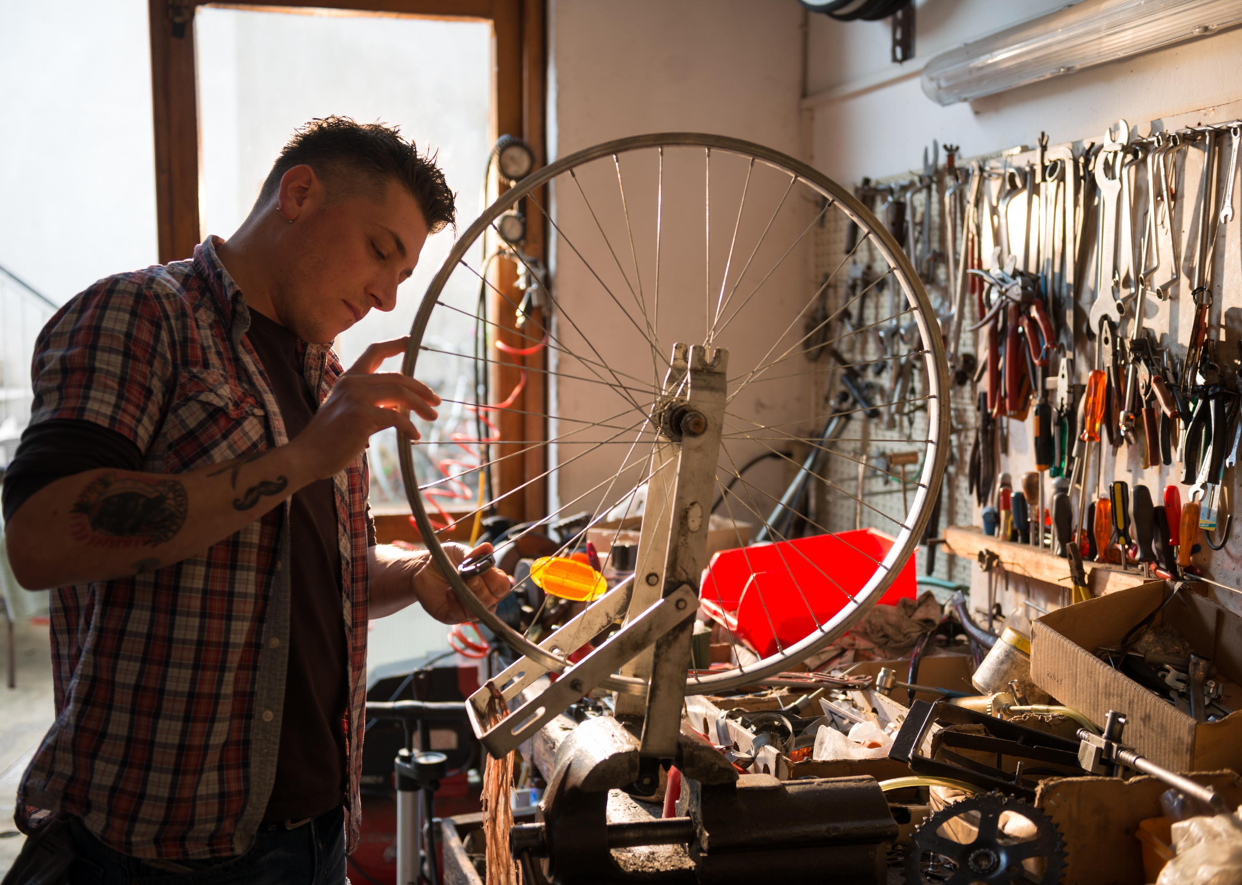 Young adult working in a biking repair shop.