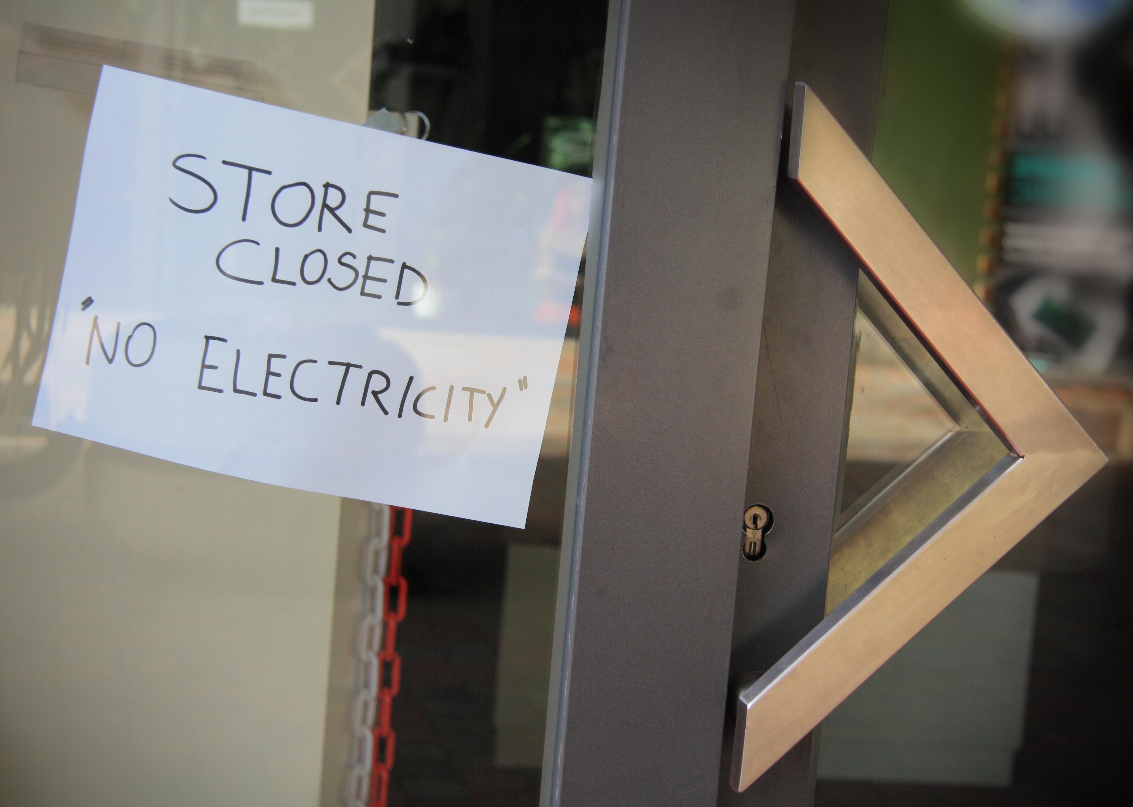 Sign posted in a shop window: Shop closed, no electricity.