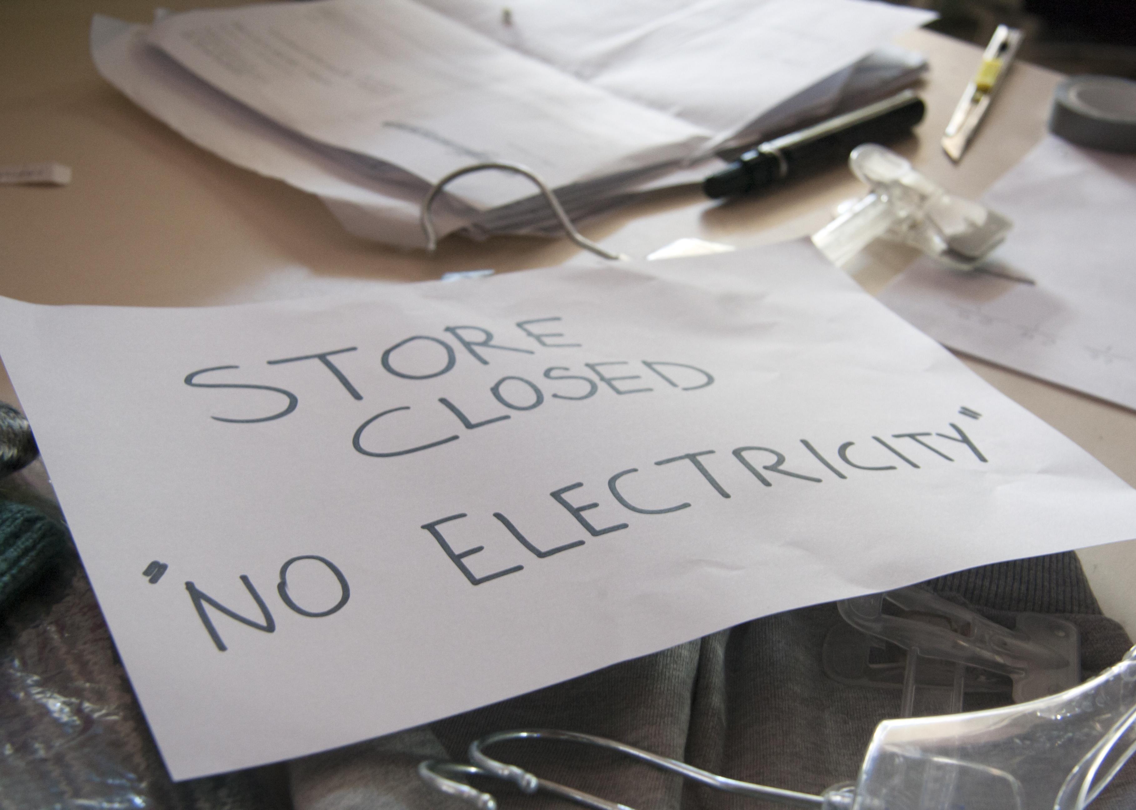 Sign on the desk of the shop closed because of the blackout.