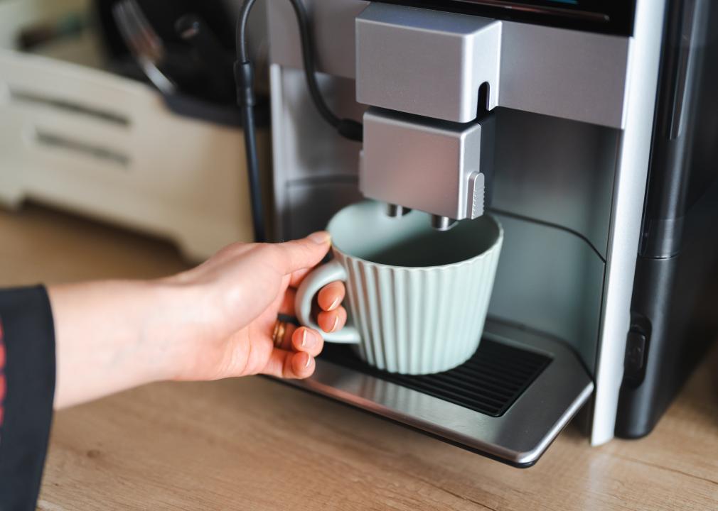 Close-up image of woman hand using coffee machine