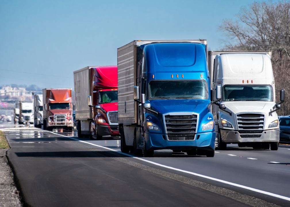 A long convoy of trucks on an interstate highway.