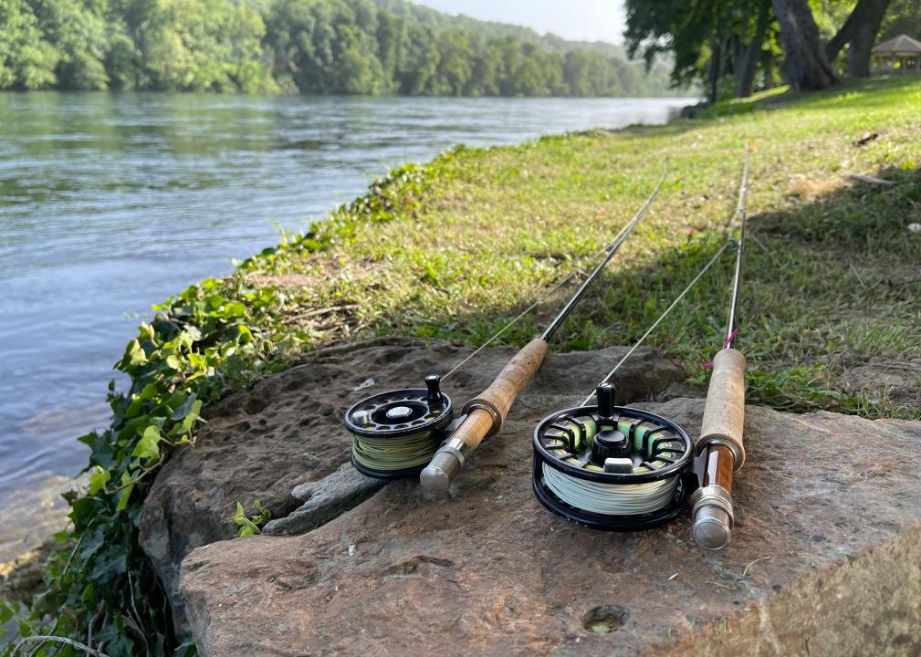 Two fly rods laying on the bank of a trout stream.