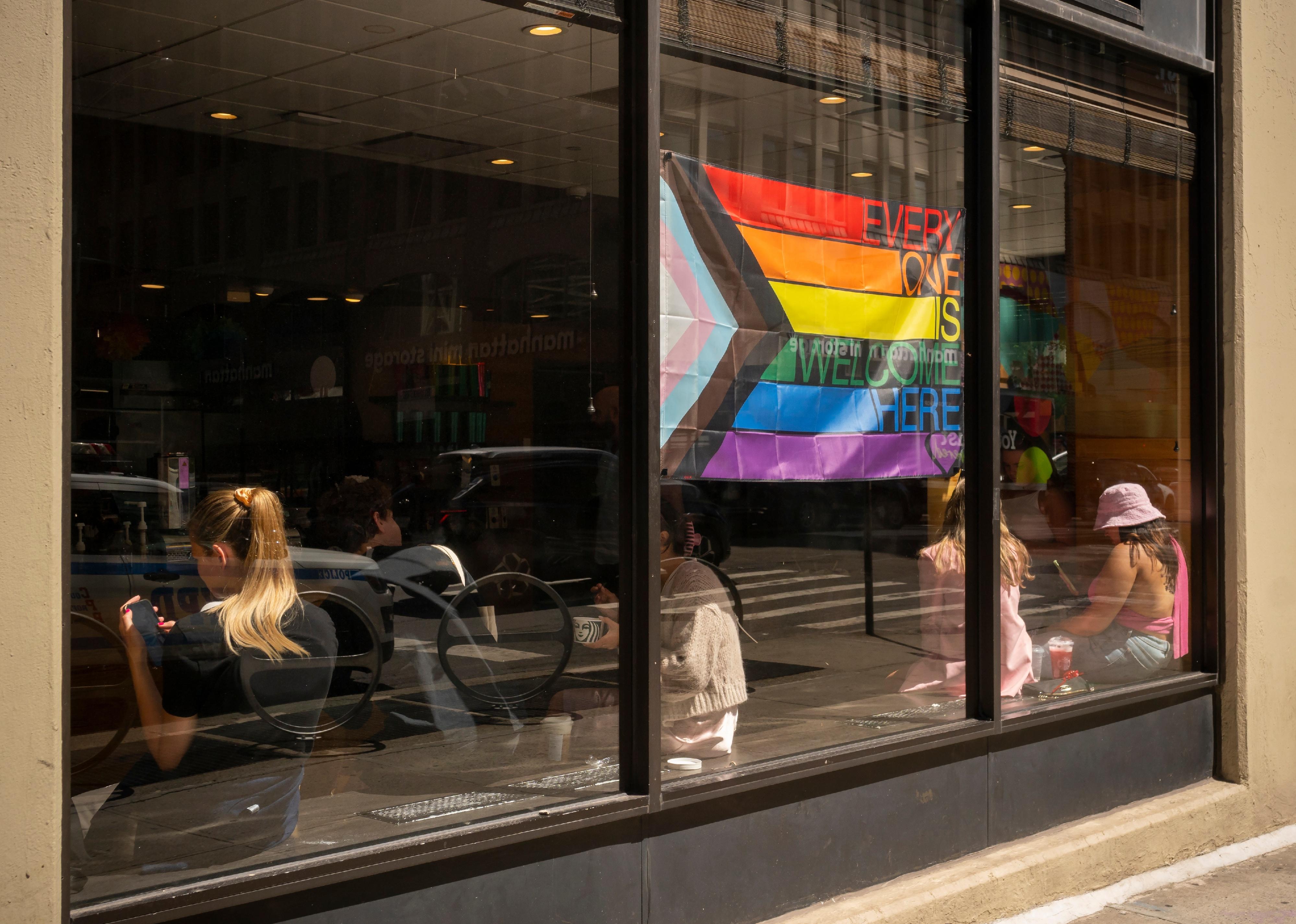 Pride progress flag in window of coffee shop