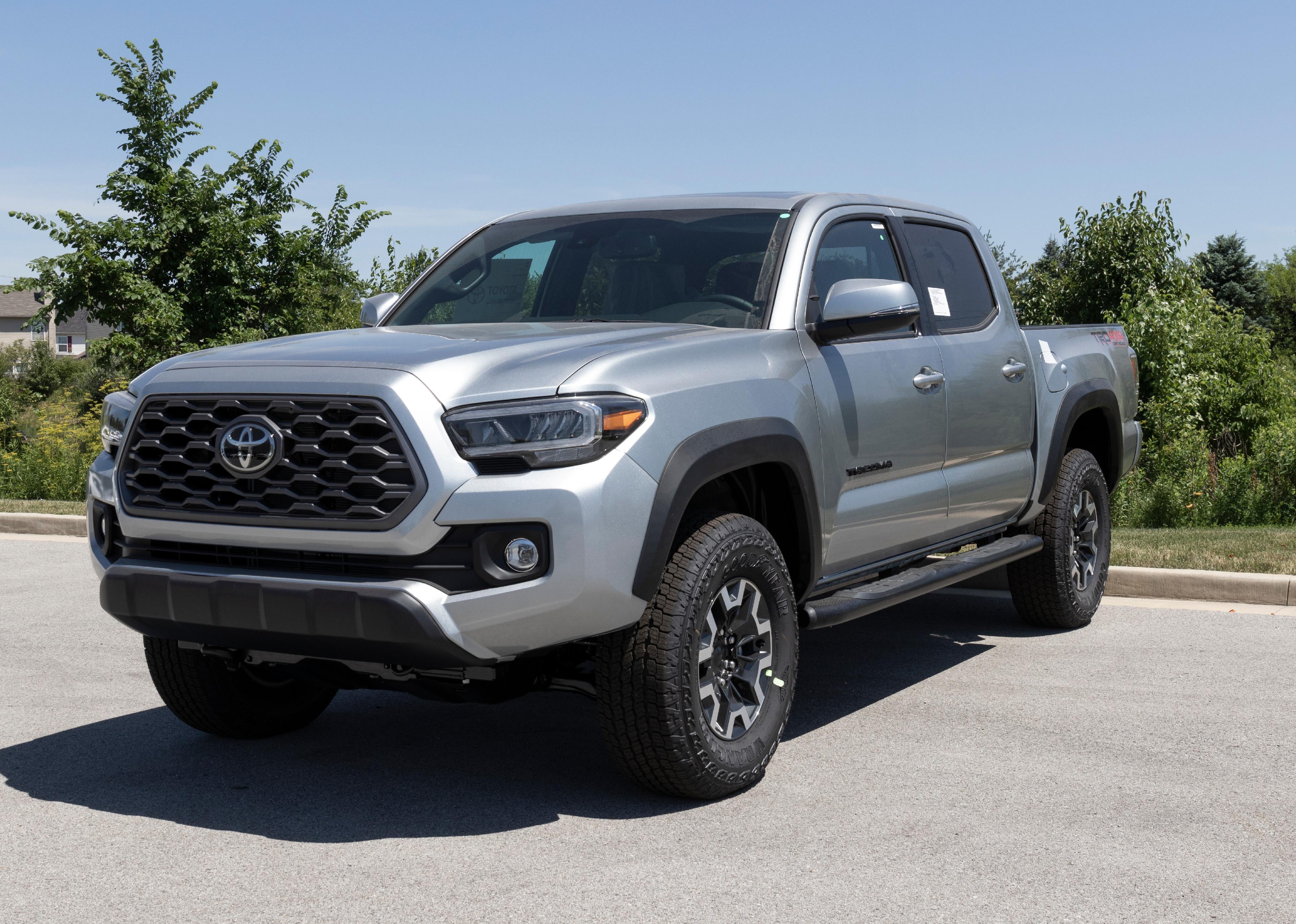 Silver Toyota Tacoma on display in parking lot.