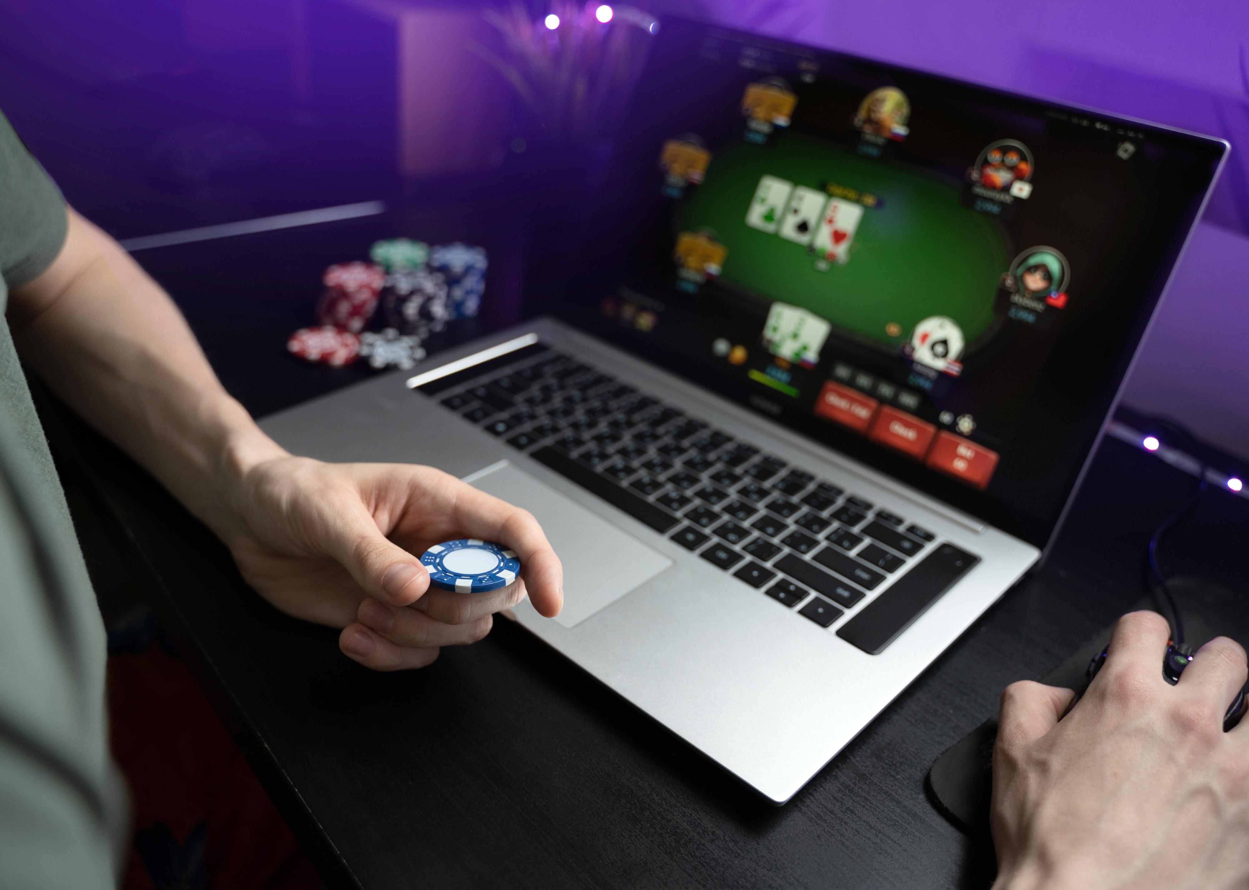Young man plays online poker on laptop.