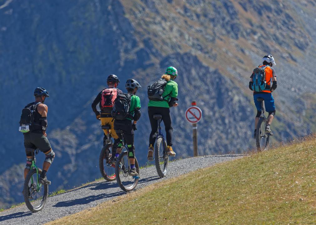 A group of unicyclers on the paths of the Croix de Chamrousse, a summit in the French Alps.