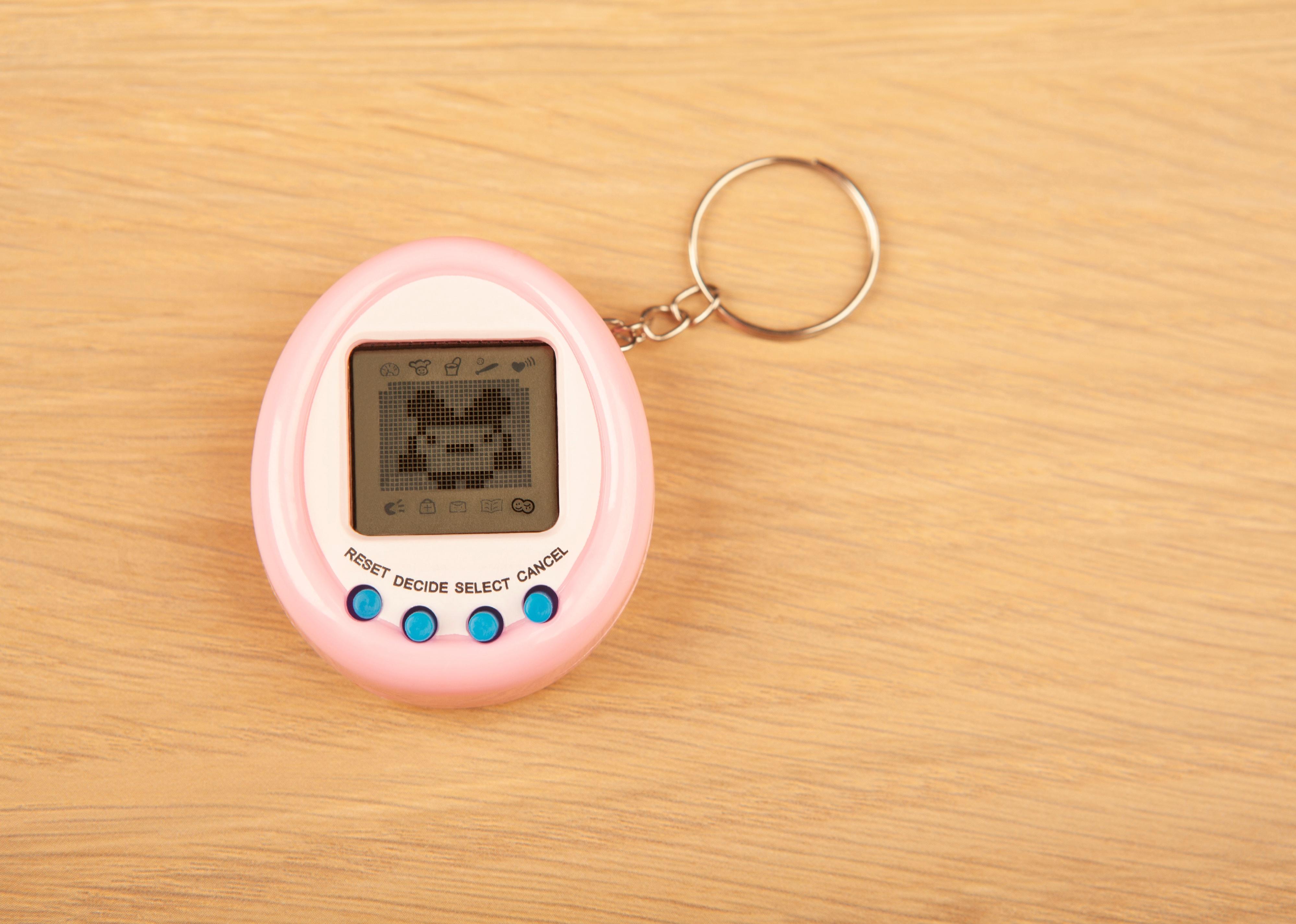 Image of Tamagotchi on wooden table.