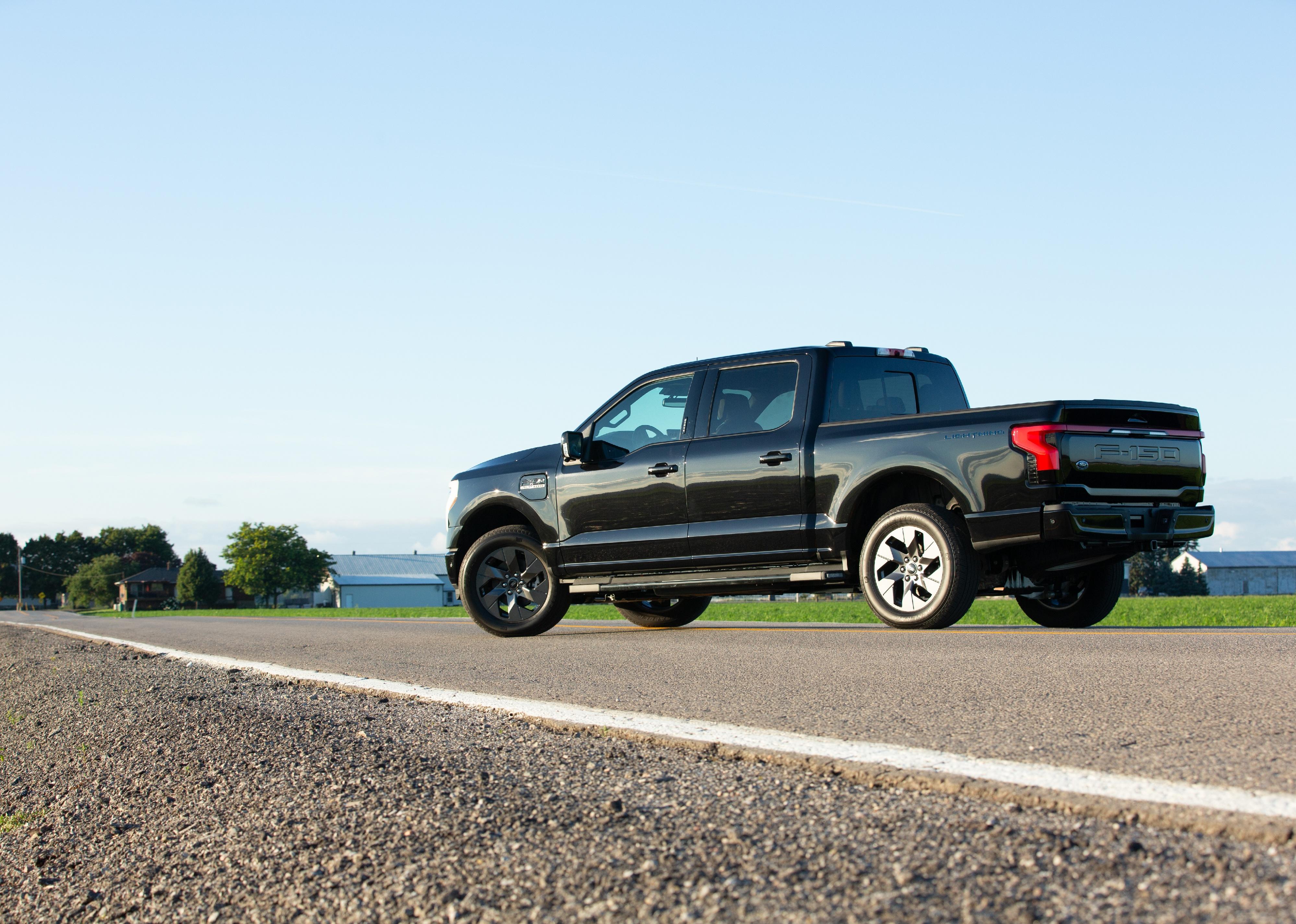 A black Ford F150 driving.