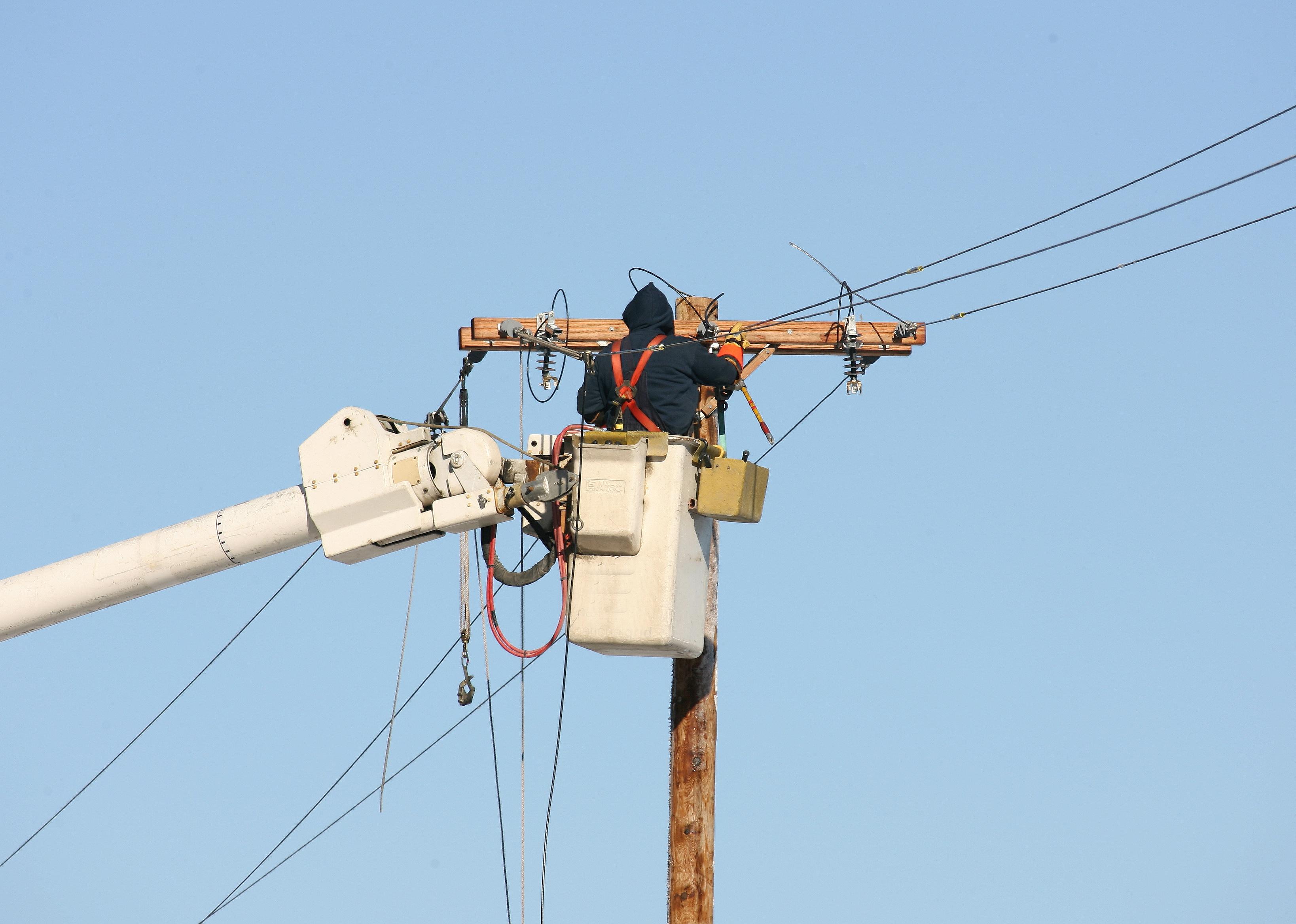 Lineman make repairs to downed power lines.