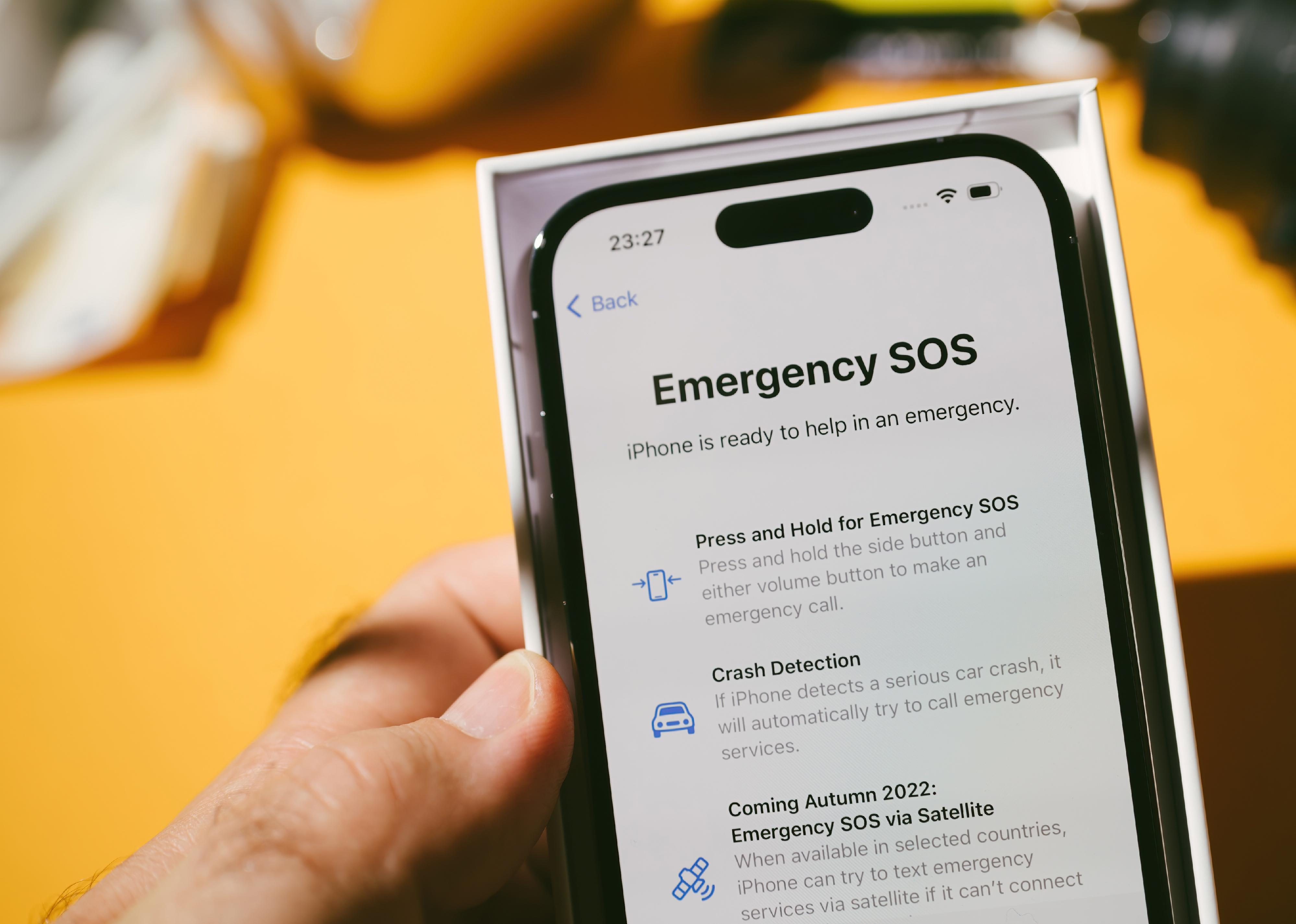 Person's hand holding iPhone with Emergency SOS menu.