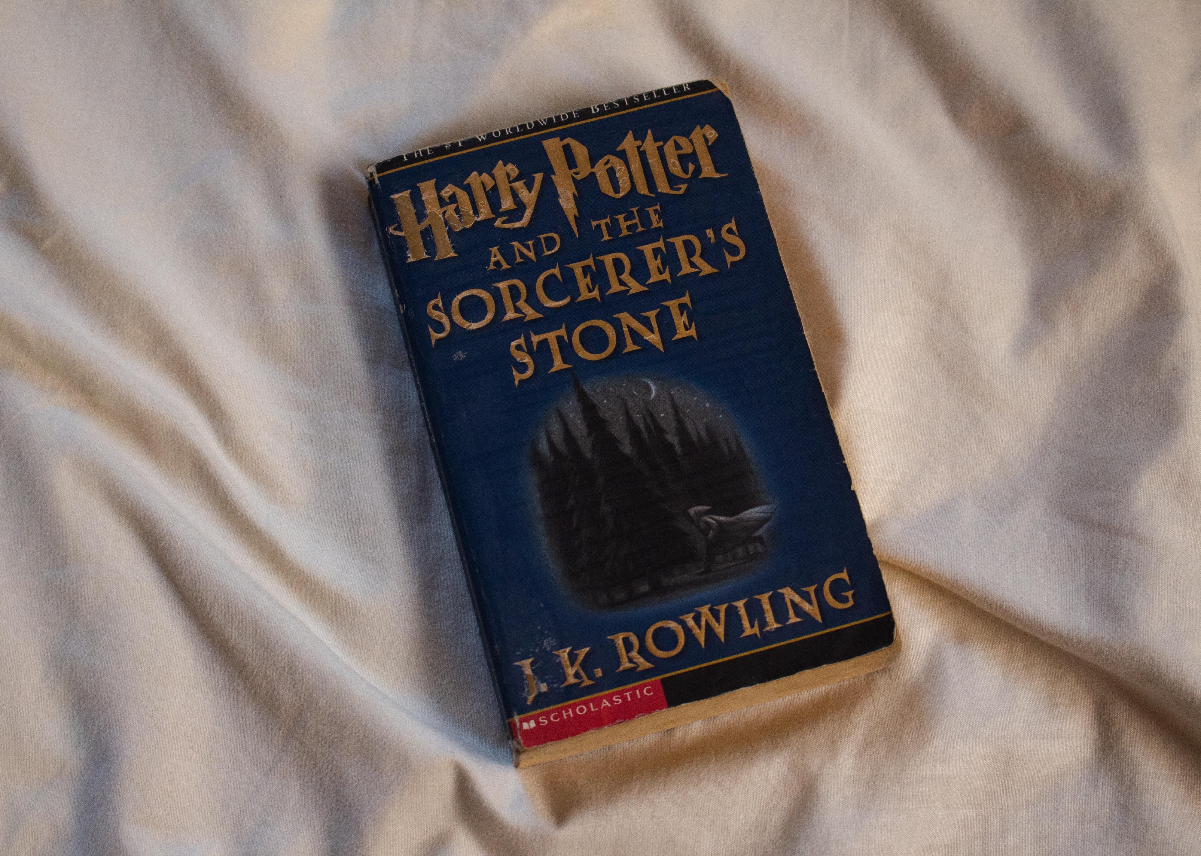 'Harry Potter and the Sorcerer's Stone' book on bed sheet.