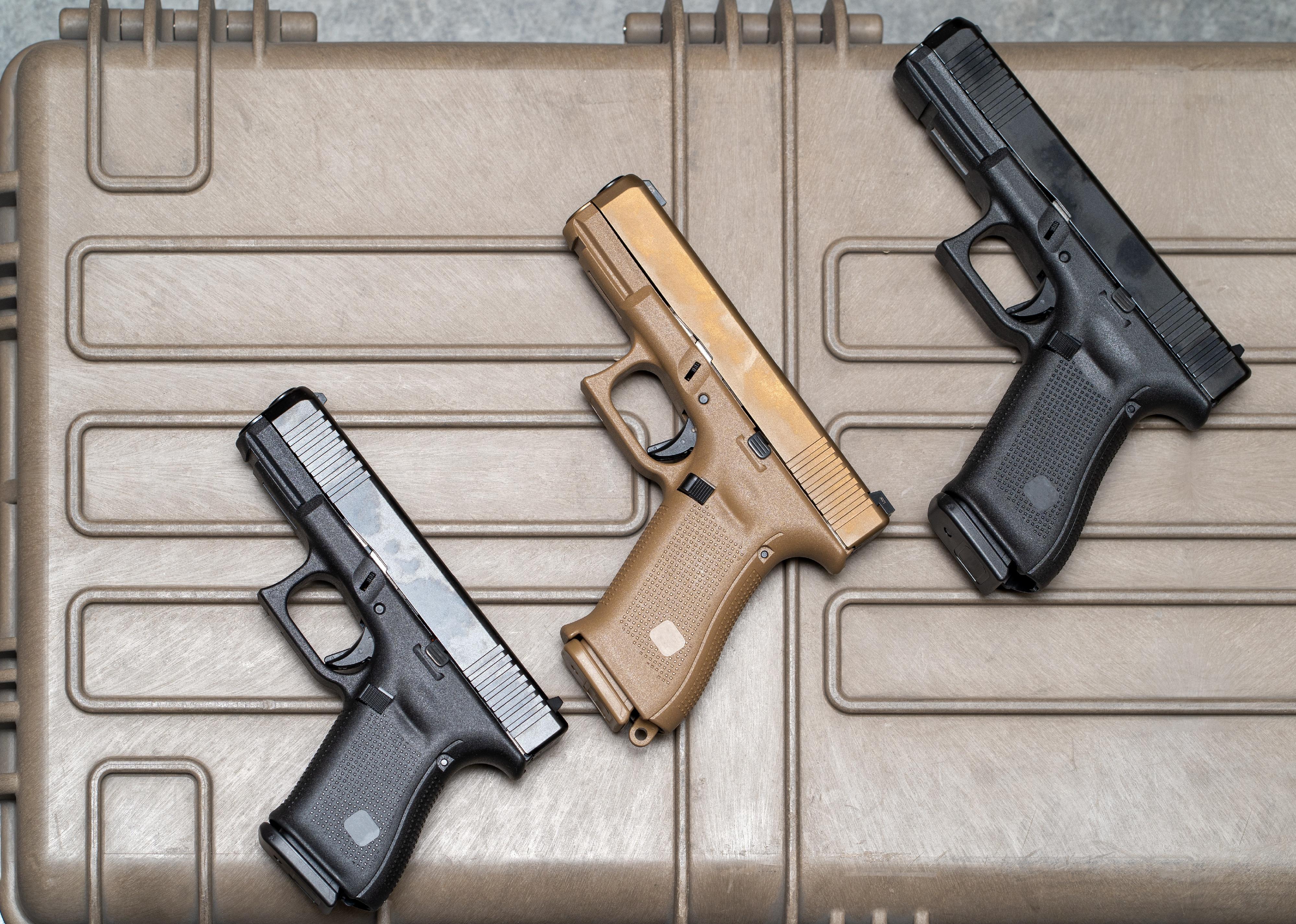 Close up of three pistols laying down.
