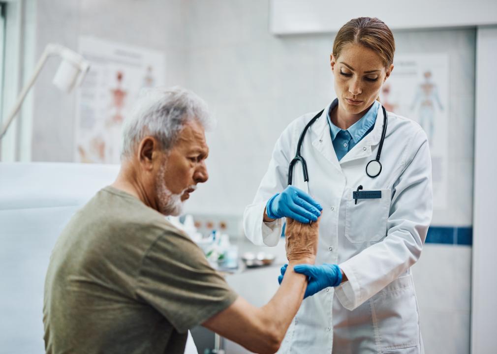 Therapist checking senior patient's hand at a medical clinic.