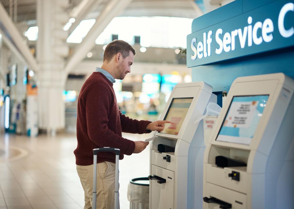 Man in the airport at a self service kiosk for check in.