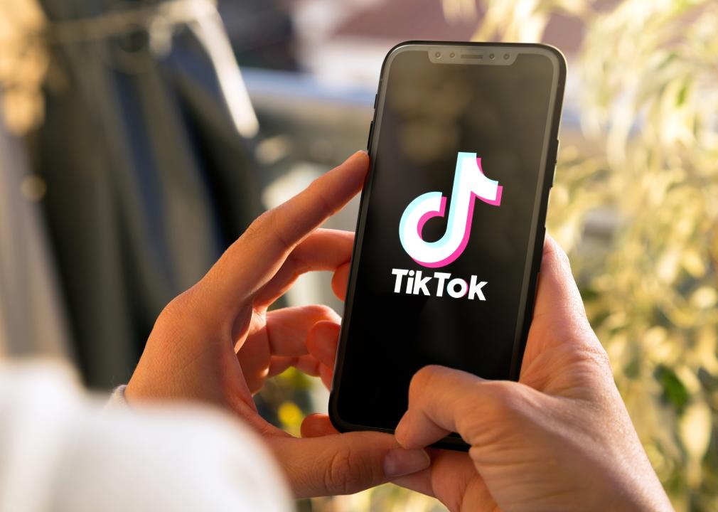 Person holding a smartphone with the TikTok app open.