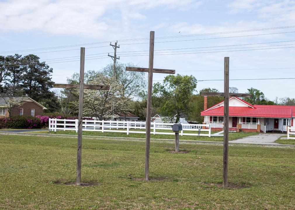 Three brown outdoor wooden crosses at a church in Laurinburg, North Carolina.