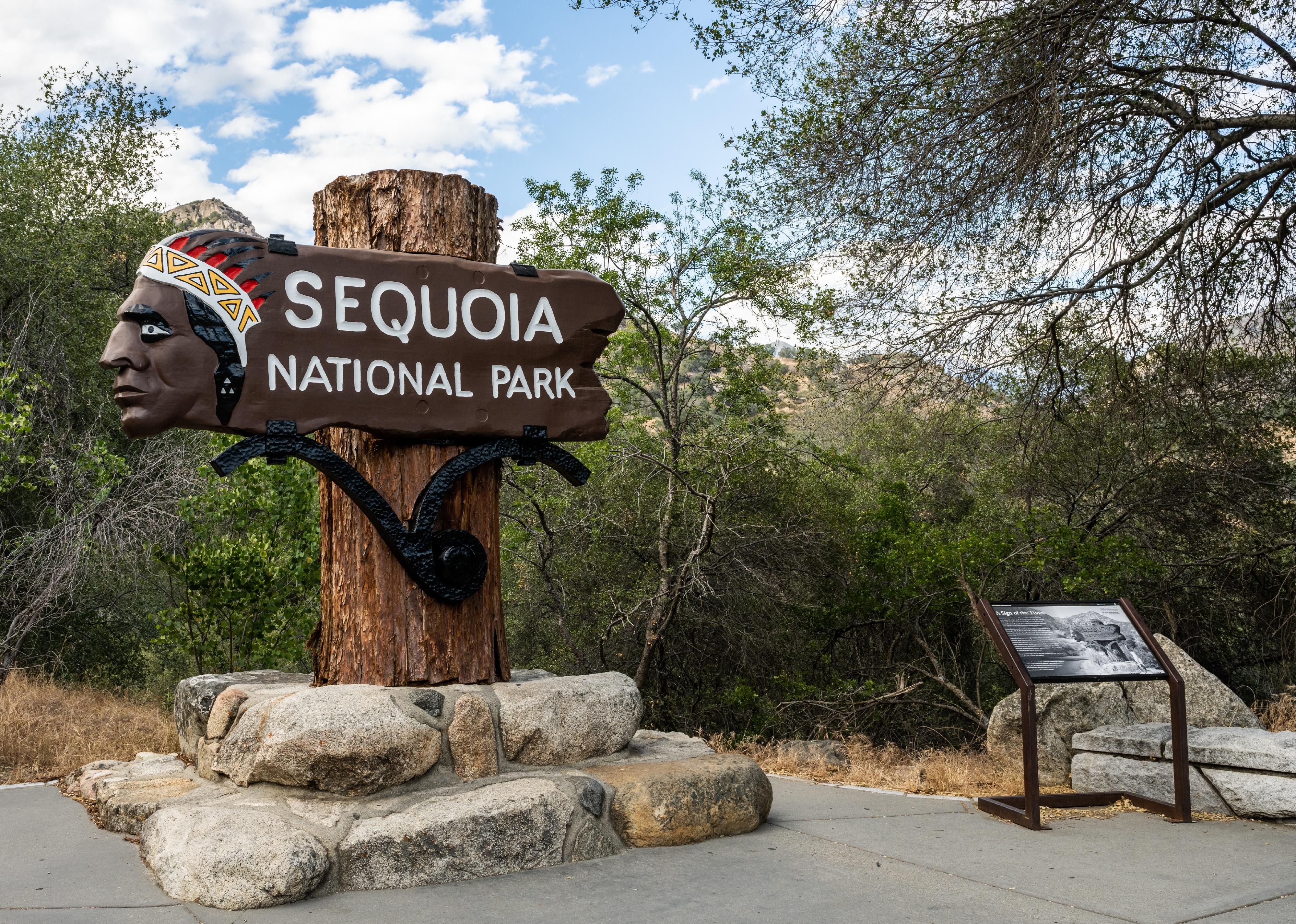 Sequoia National Park welcome sign with historical marker to the right.