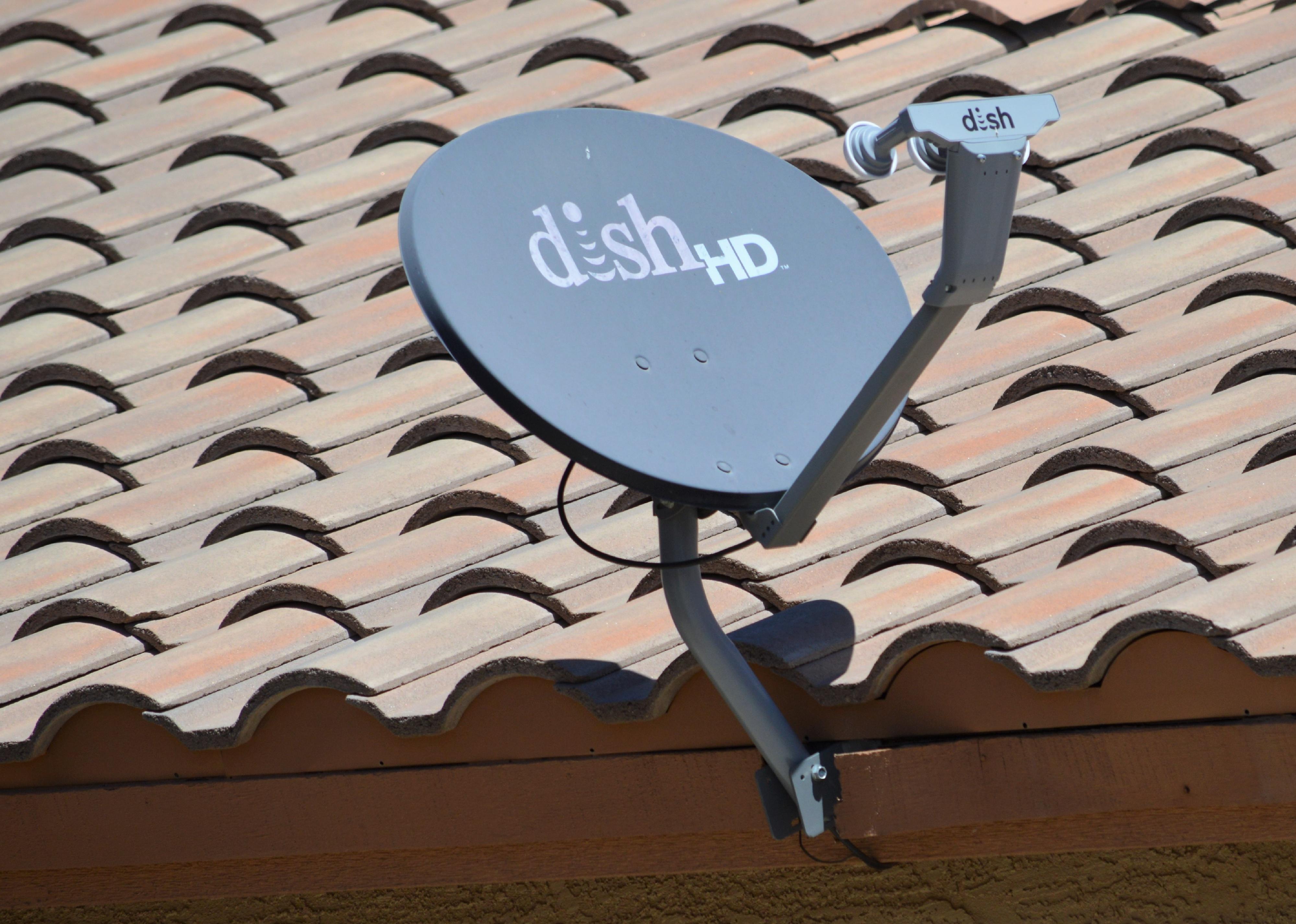 A DISH HD Network satellite TV receiver mounted on a residential home roof. 