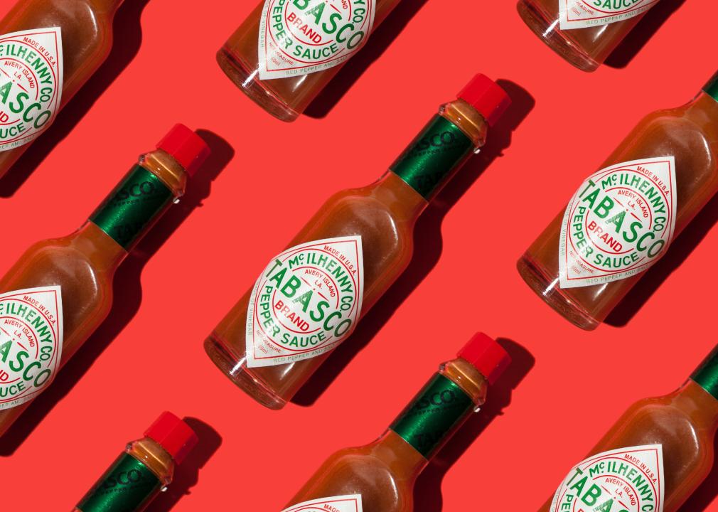 Spicy tabasco sauce on red background pattern.