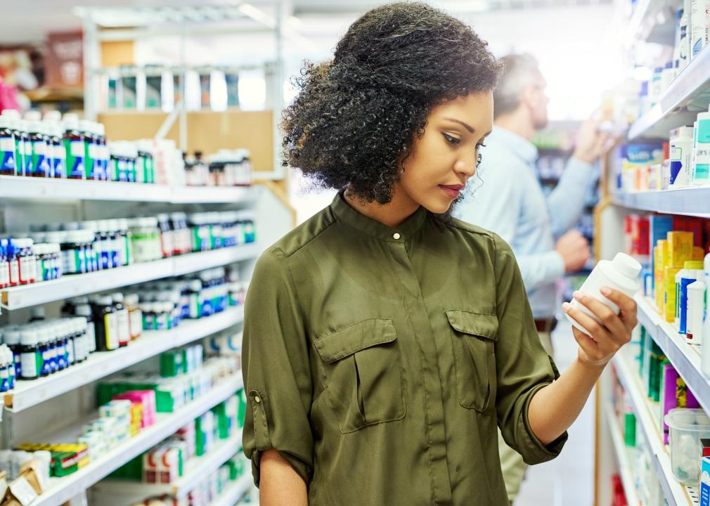 Woman looking at ingredients on drugstore pills.