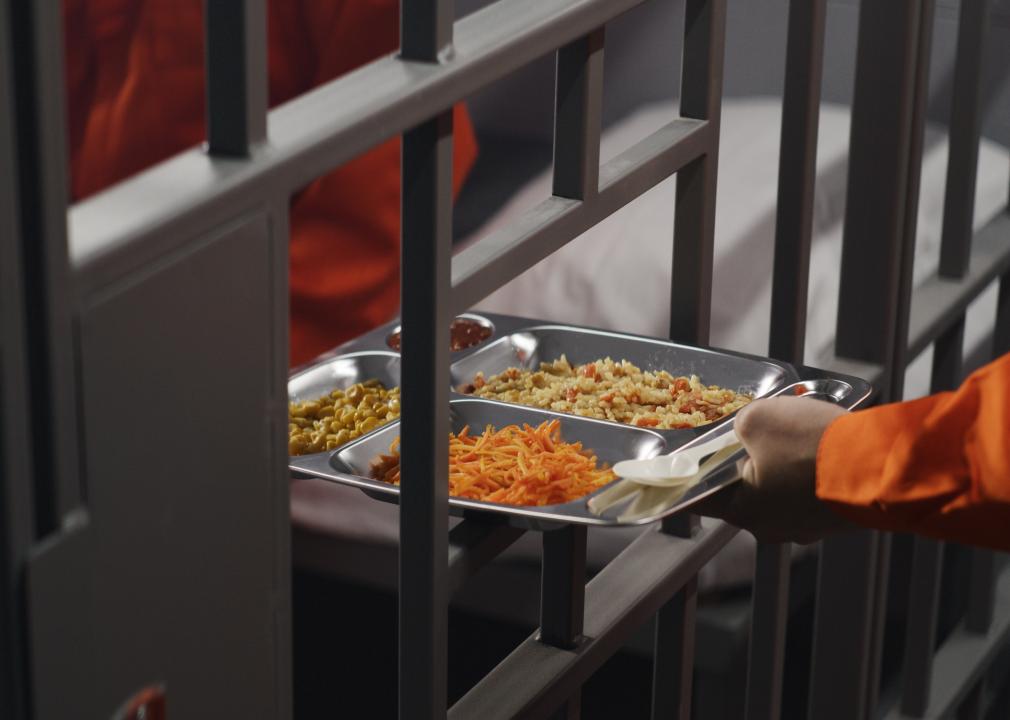 Prison tray of food passed through metal bars.