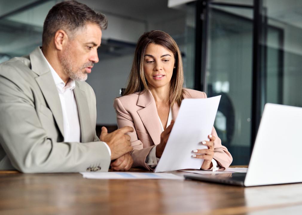 Two business executives discussing financial papers.