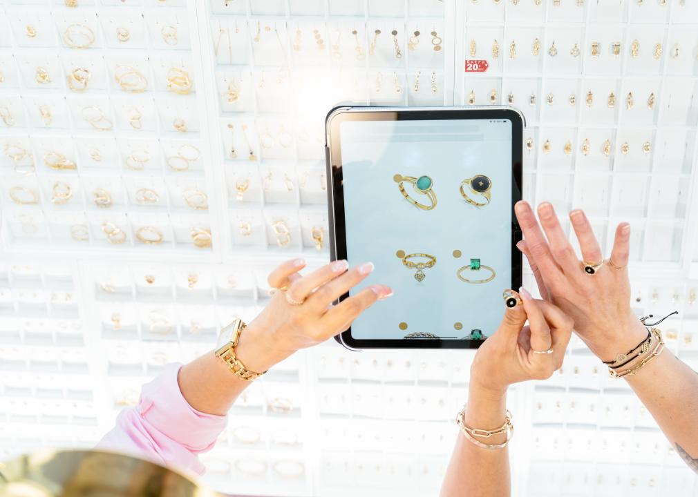 View from above of hands in front of a digital tablet that is set up in a jewelry store. 