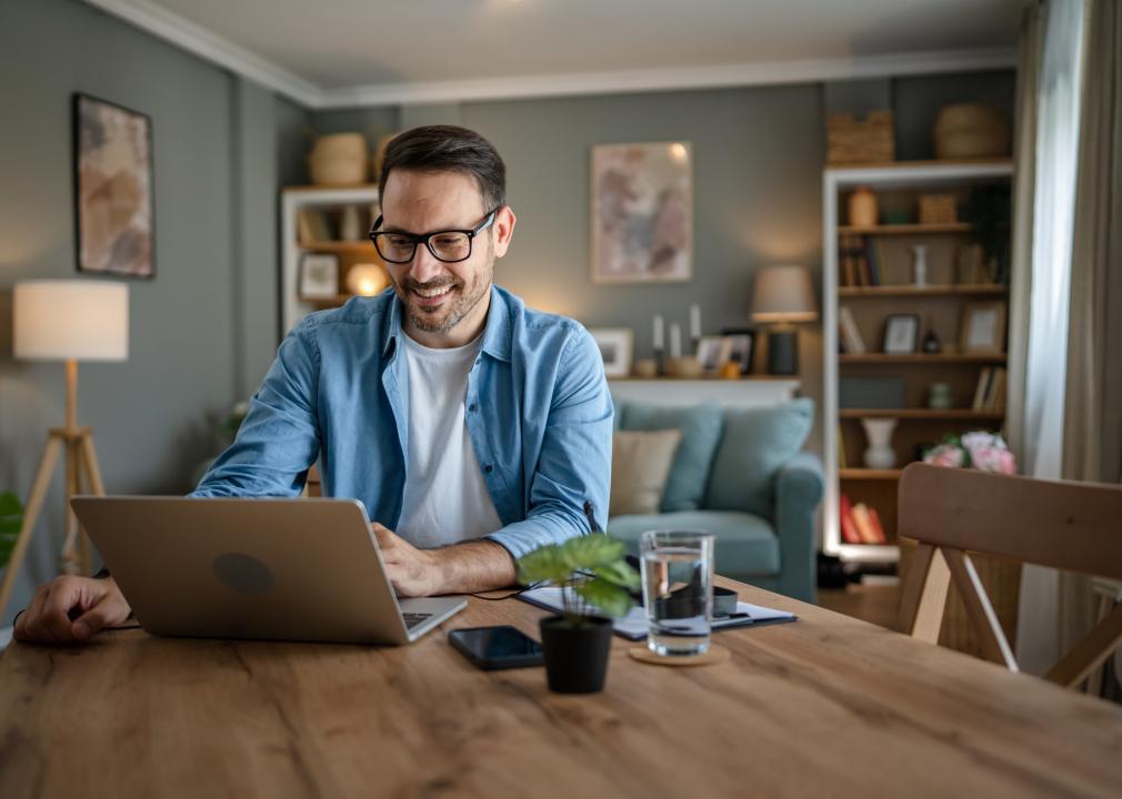 Man working on his laptop at his kitchen table. 