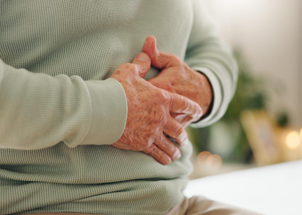 Closeup of woman holding stomach.