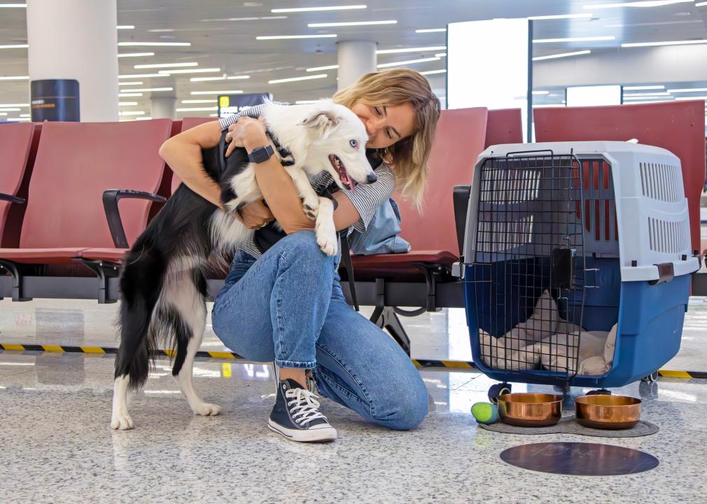 Woman and dog in waiting area of airport.