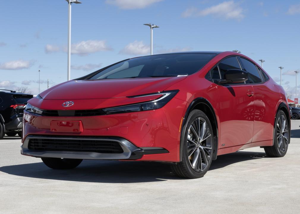 A red Toyota Prius XLE Electric Vehicle on display outside in a lot.