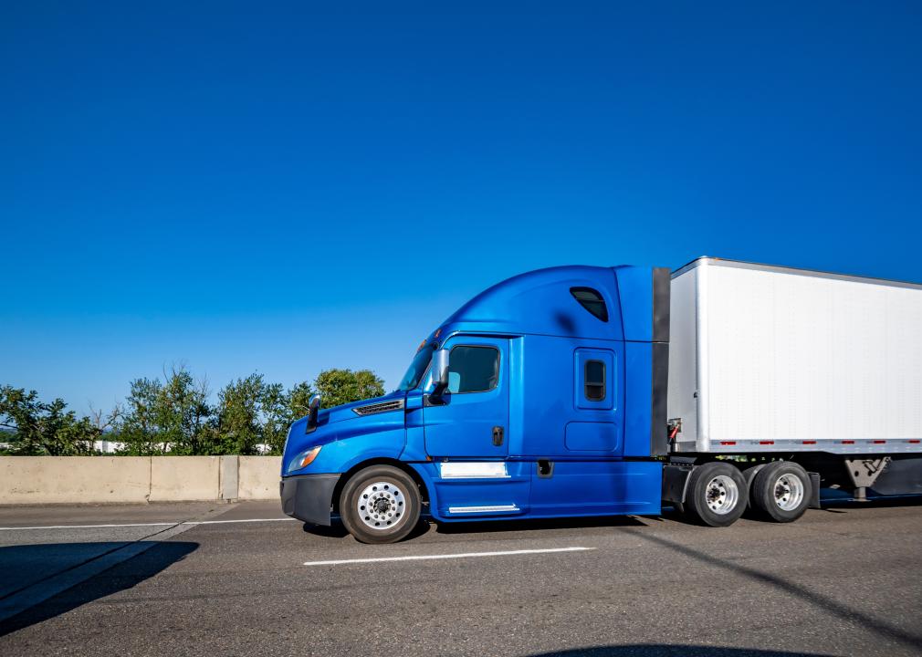 Side view of a blue semitruck on road.