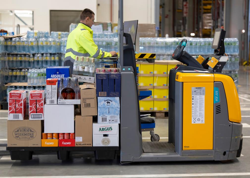 Worker operating a pallet mover in a warehouse.