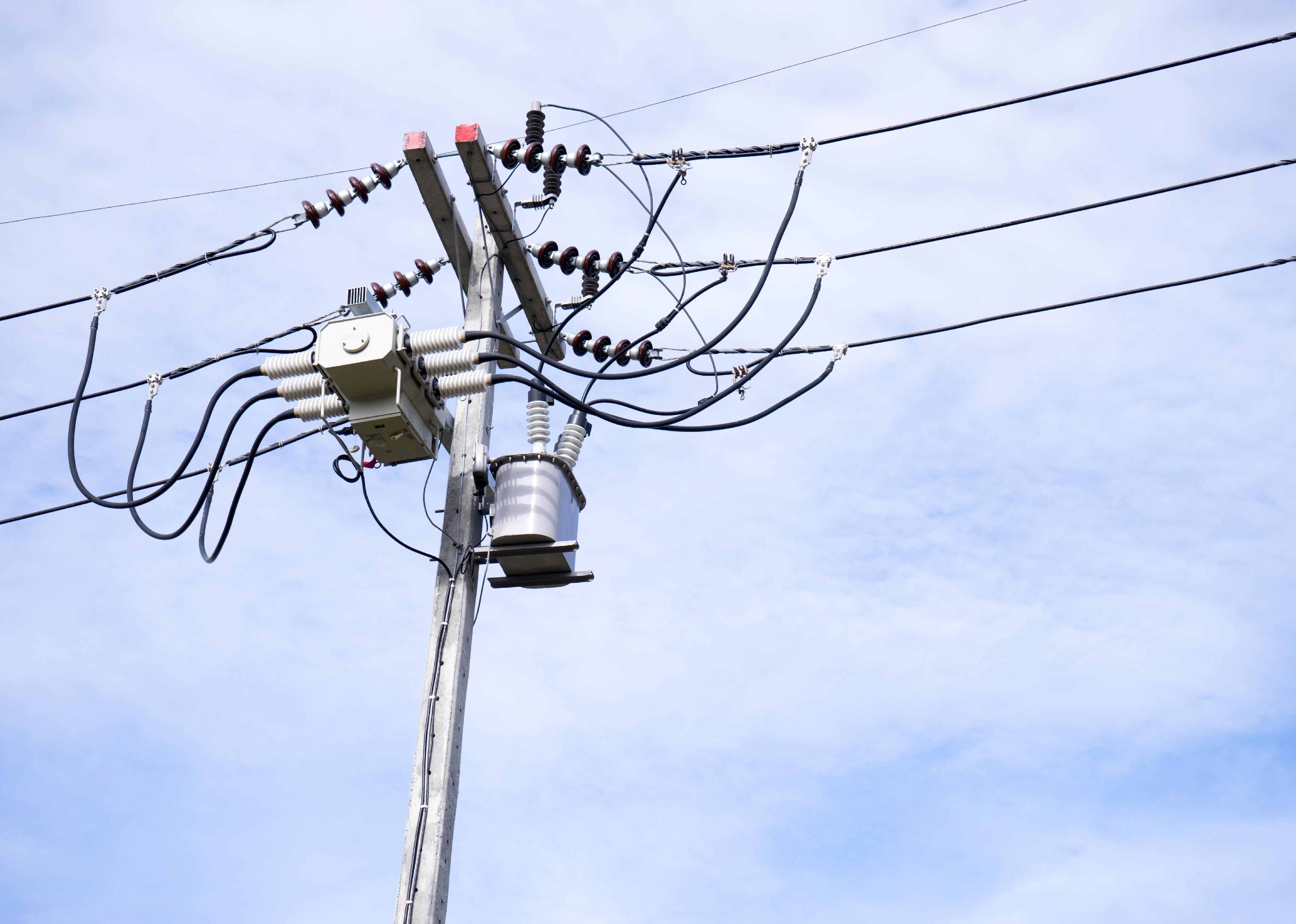 Power lines and a pole against blue sky.