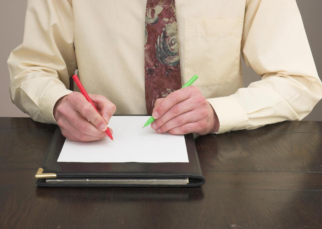 A person's hands holding a pen to paper in each hand. 