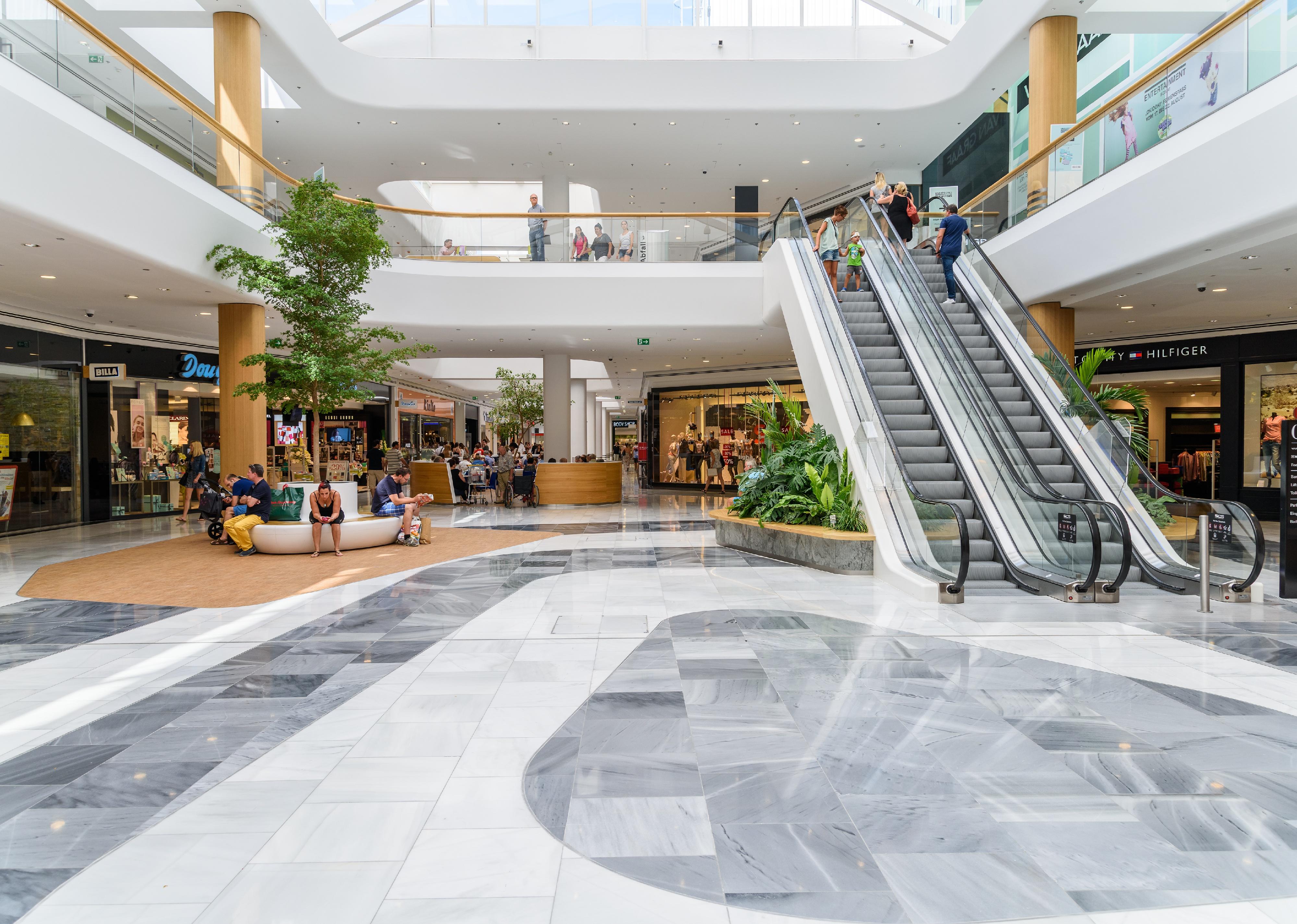 Interior of a shopping mall with escalators.