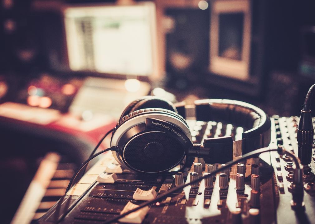 Close-up of headphones laying on recording studio equipment.