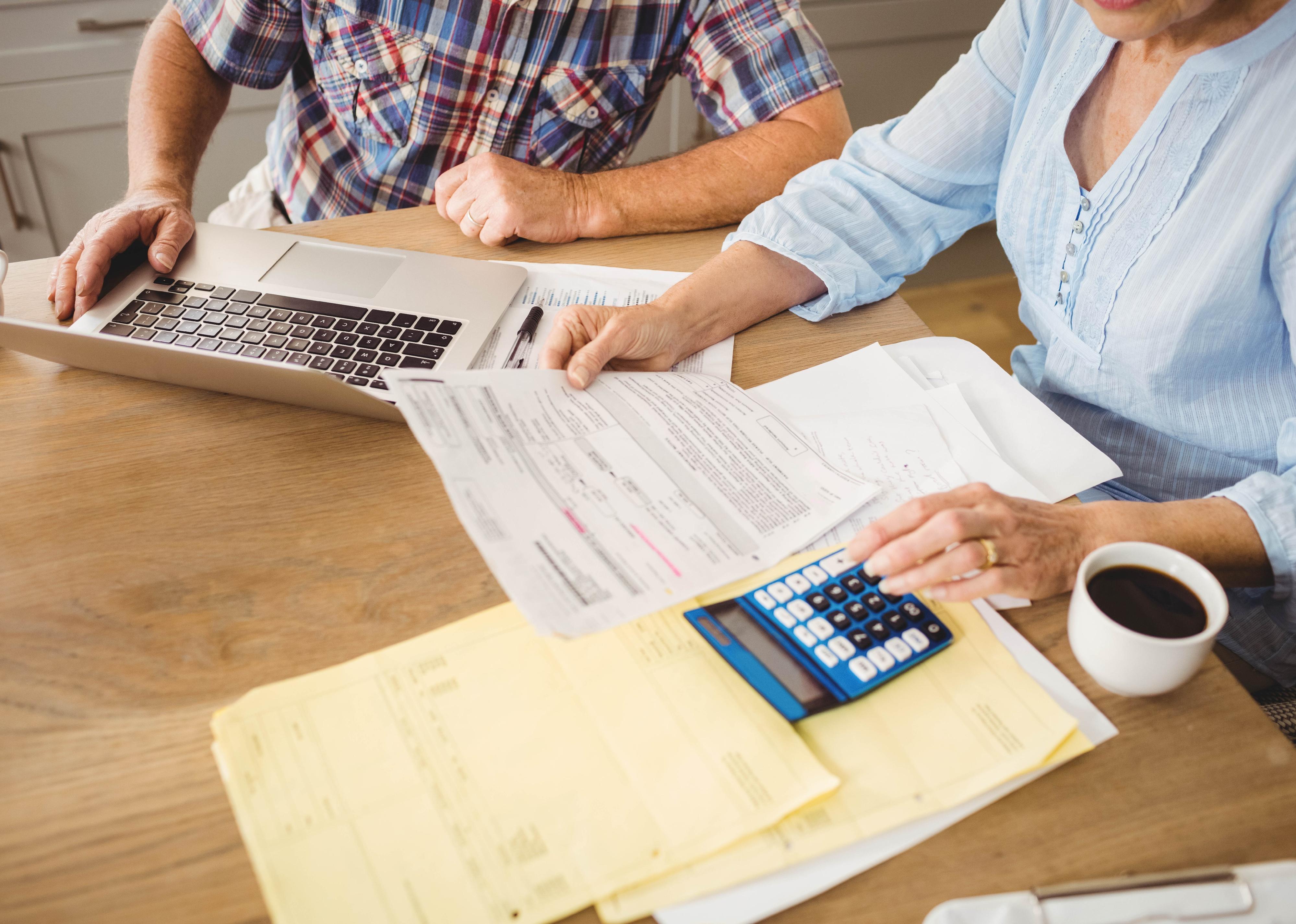 Senior couple working with their bills at home.