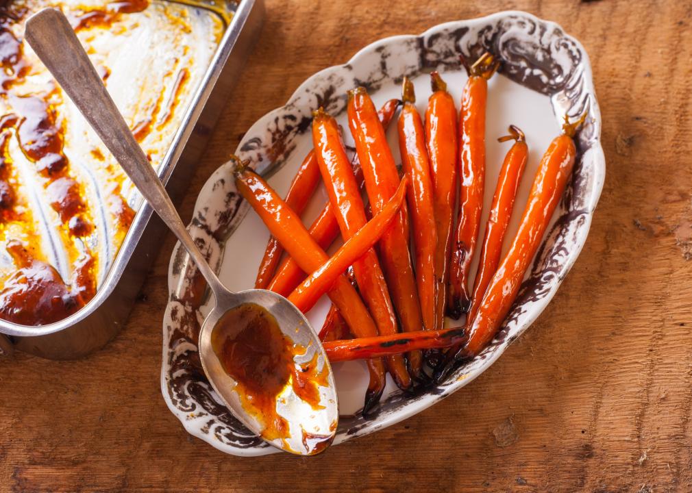 Caramelized carrots with maple syrup on white porcelain plate.