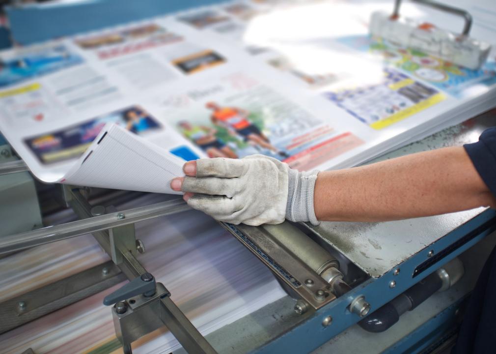 Hands on a post press finishing line machine.